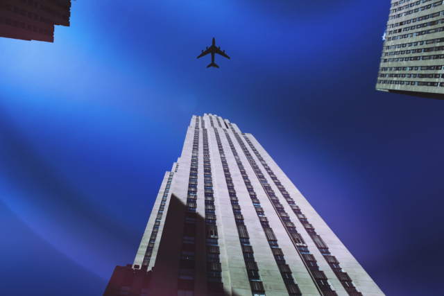 A jet flying over the Empire State Building in New York City.