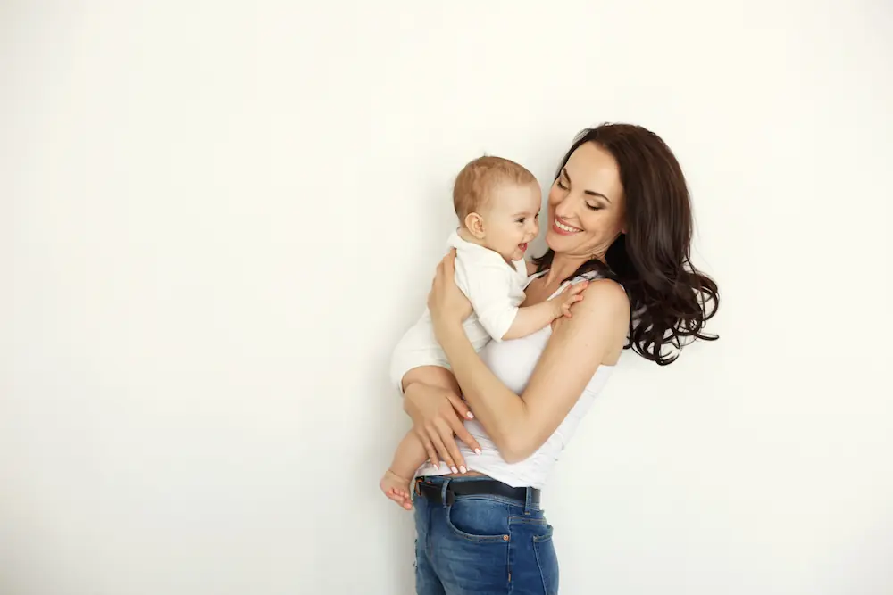 mother smiling and holding her baby